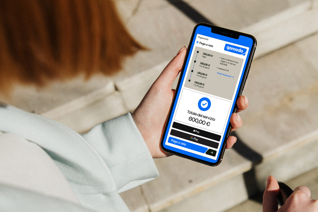 Una donna al telefono che utilizza l'app di Qomodo per pagare digitalmente un pagamento beauty