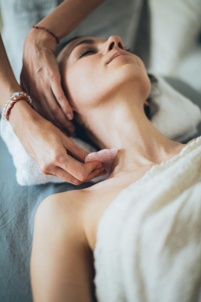 donna a cui viene passato il gua-sha per il miglioramento del sistema linfatico