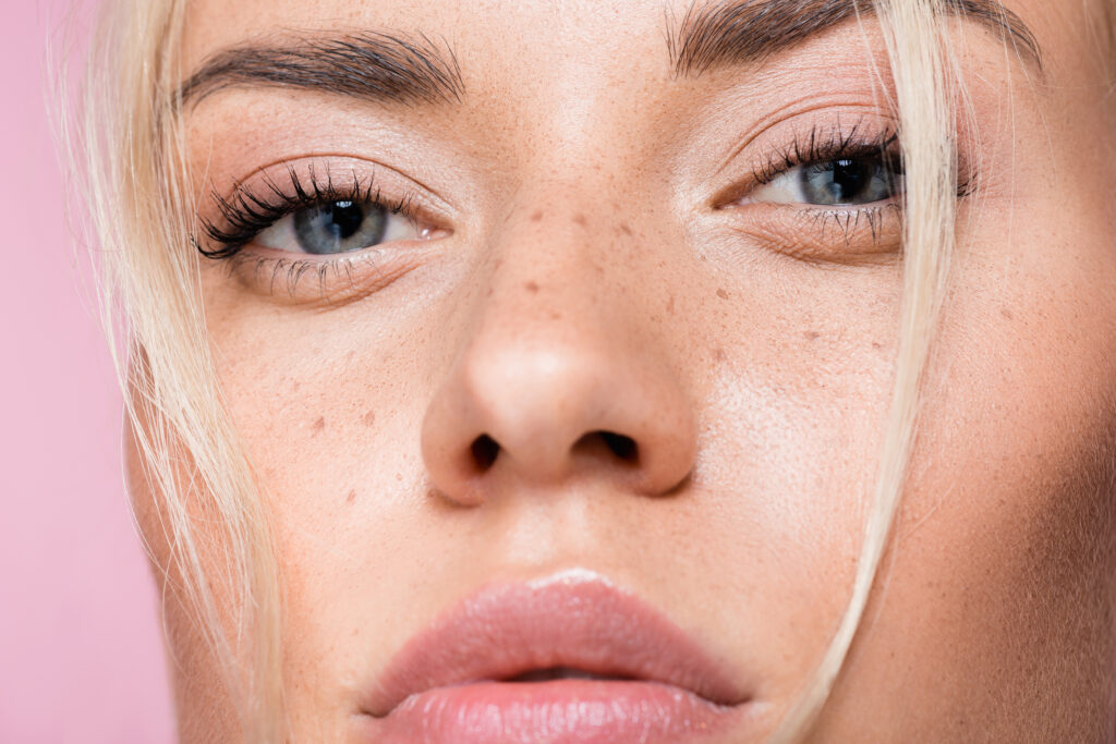 primo piano di bella donna bionda con le lentiggini isolate sul rosa, in rappresentanza della fiera Innovation Beauty Lab Rimini