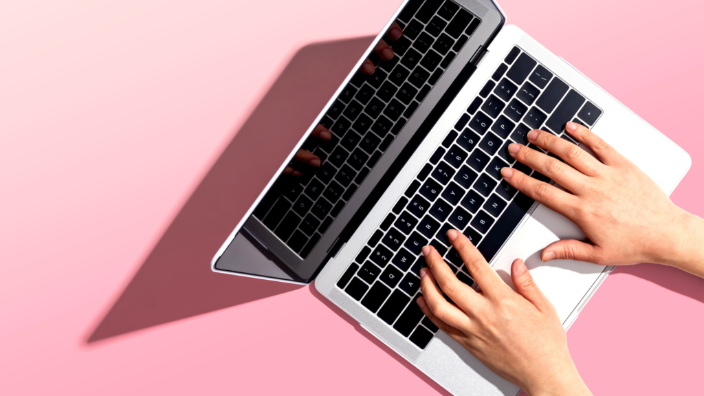 su uno sfondo rosa, è rappresentato un personal computer con delle mani che digitano qualcosa. Sta a rappresentare il software gestionale Beautycheck, per la gestione efficace di un centro estetico.