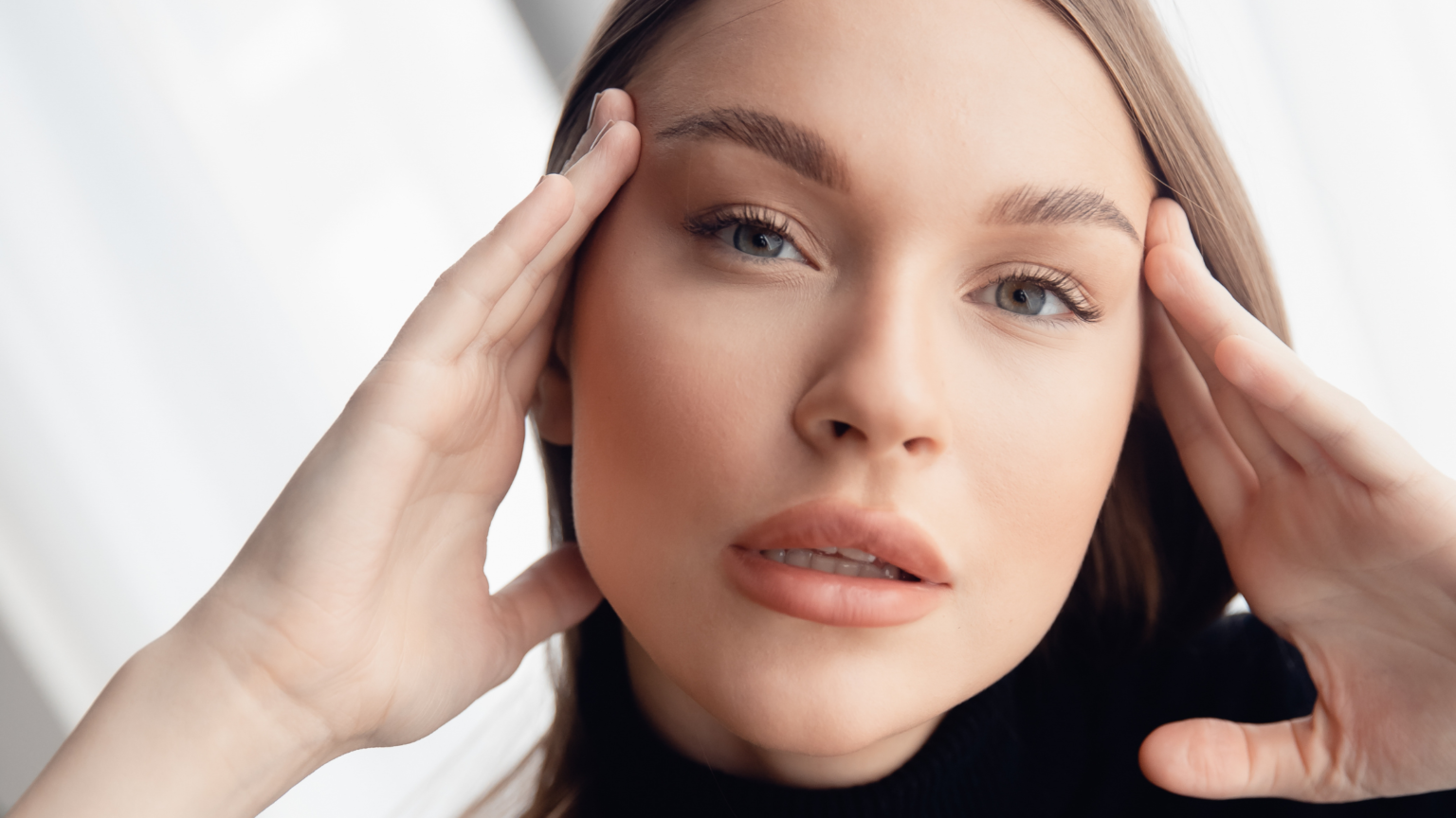una donna dai capelli rossi che si tocca le tempie: rappresenta la laminazione sopracciglia, trattamento in voga tra le persone e che rende le sopracciglia forti e belle.