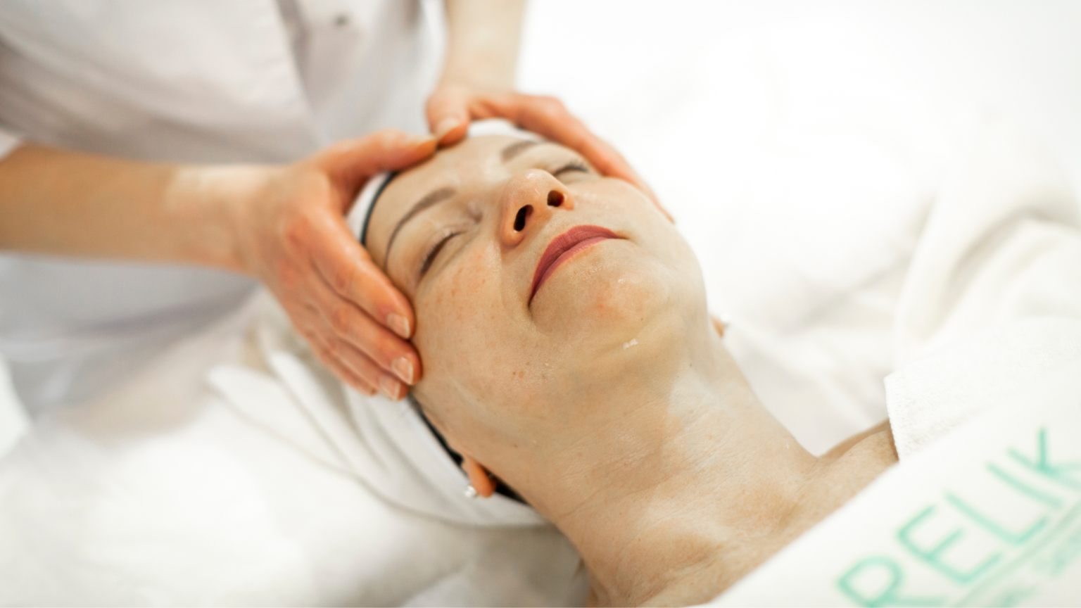 in primo piano, un viso di una donna anziana che si vede che viene massaggiato da un'estetista. Rappresenta la tendenza della longevity, esposta al cosmoprof bologna.
