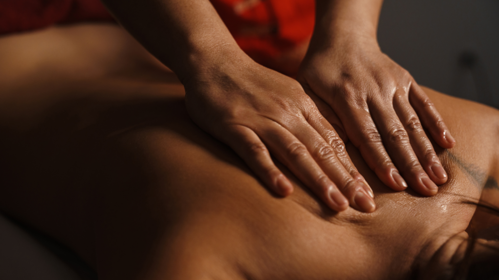 Mani esperte che eseguono un massaggio rilassante su una schiena leggermente oliata, creando un’atmosfera di benessere e comfort. L’immagine rappresenta l’essenza dei trattamenti SPA, con un focus sul contatto delicato e sulla cura personalizzata per rigenerare corpo e mente.