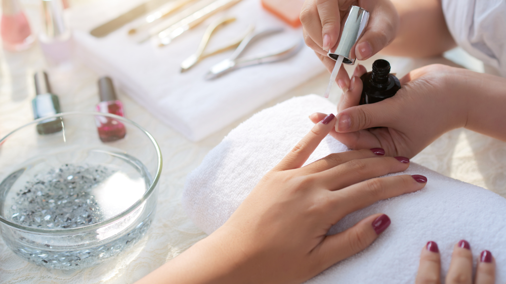 in foto, delle mani di una professionista che fa una manicure: rappresenta il tema dell'articolo, il codice ateco onicotecniche.