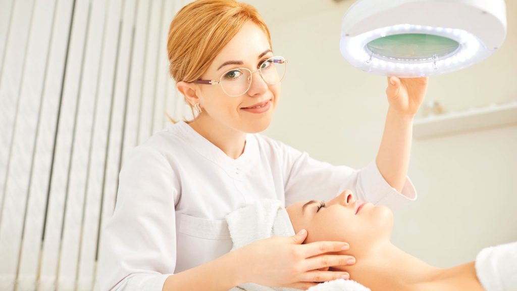 Diventare estetista: professionista esegue un trattamento viso su una cliente all'interno di un centro estetico.