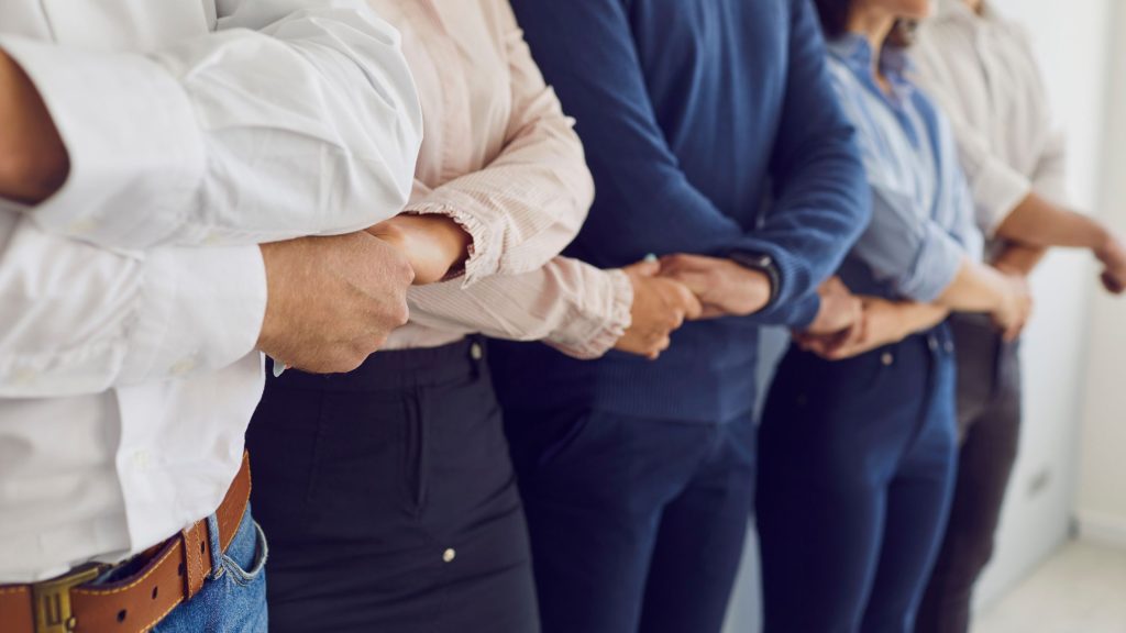 in foto delle persone che si tengono per mano. rappresentano le associazioni di categoria.